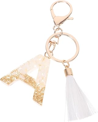 Abaudem alphabet keychain with initial letter with white pompom, resin pendant, bohemian keychain for car, bag and wallet for girls.. Affordable luxury and fast service — only on DIAYTAR Nigeria.